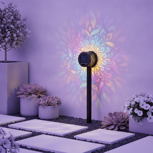 Close-up of a single GloPetal solar light, shaped like a glowing white flower, in a modern garden with soft lavender and whit